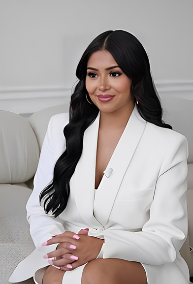 A woman in white jacket sitting on couch.